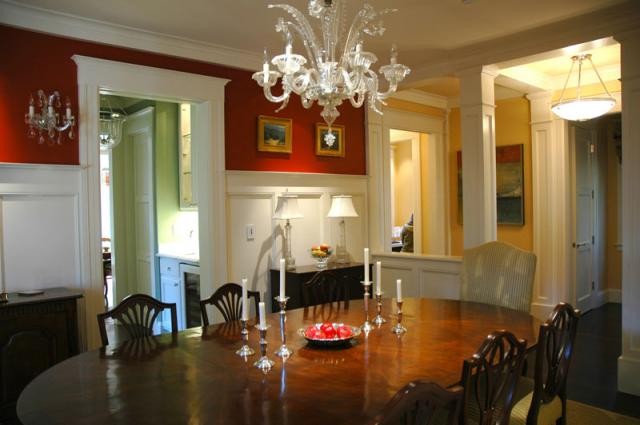 Immagine di una sala da pranzo chic chiusa e di medie dimensioni con pareti rosse, parquet scuro e pavimento marrone