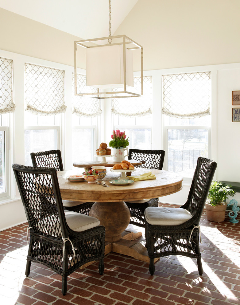Elegant brick floor dining room photo in New York with beige walls