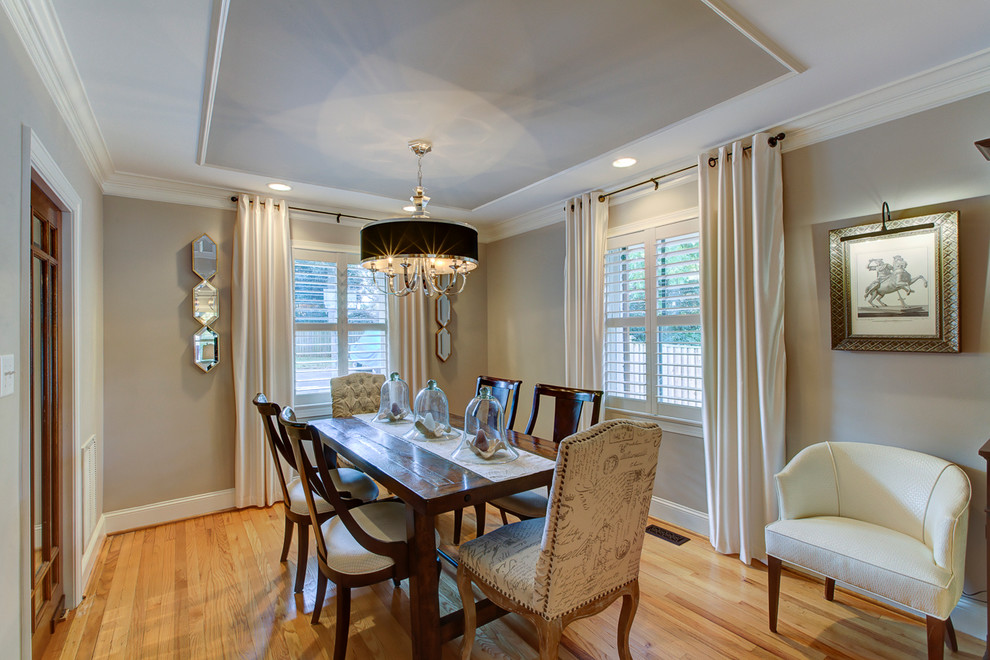 Exemple d'une salle à manger ouverte sur le salon chic de taille moyenne avec un mur beige, parquet clair, aucune cheminée et un sol marron.