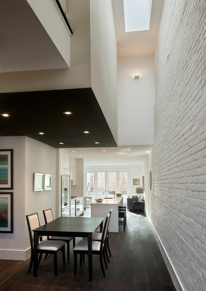 Esempio di una sala da pranzo aperta verso la cucina contemporanea con pareti bianche, parquet scuro e pavimento marrone