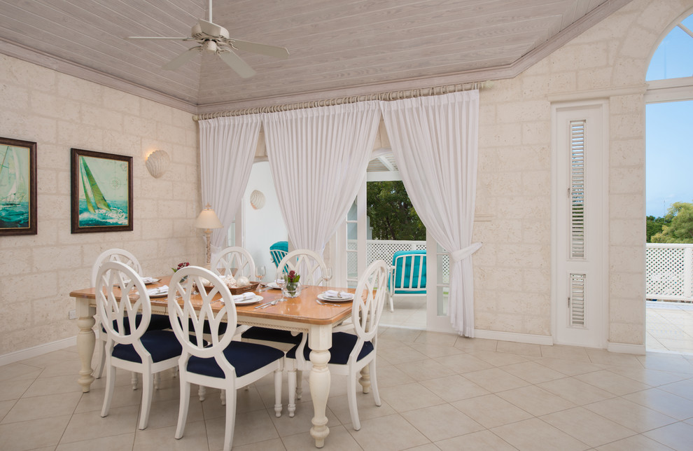 На фото: большая гостиная-столовая в морском стиле с белыми стенами и полом из керамической плитки