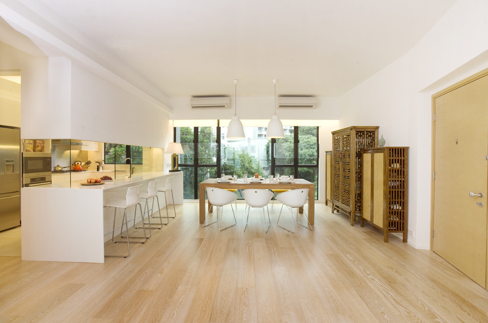 Immagine di una sala da pranzo aperta verso la cucina minimal con pavimento beige