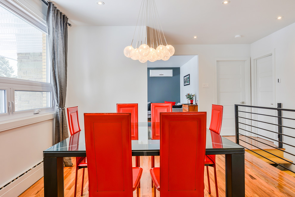 Design ideas for a modern dining room in Montreal with white walls, medium hardwood flooring and no fireplace.