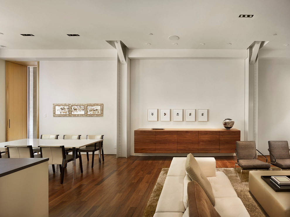 Example of a minimalist dark wood floor great room design in Philadelphia with white walls