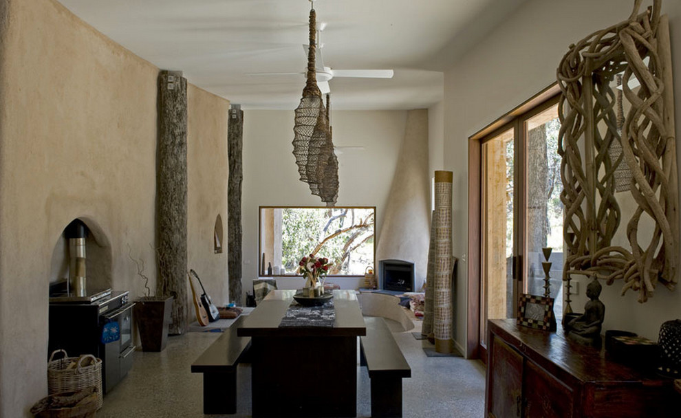 На фото: гостиная-столовая среднего размера в стиле кантри с бежевыми стенами, бетонным полом и угловым камином