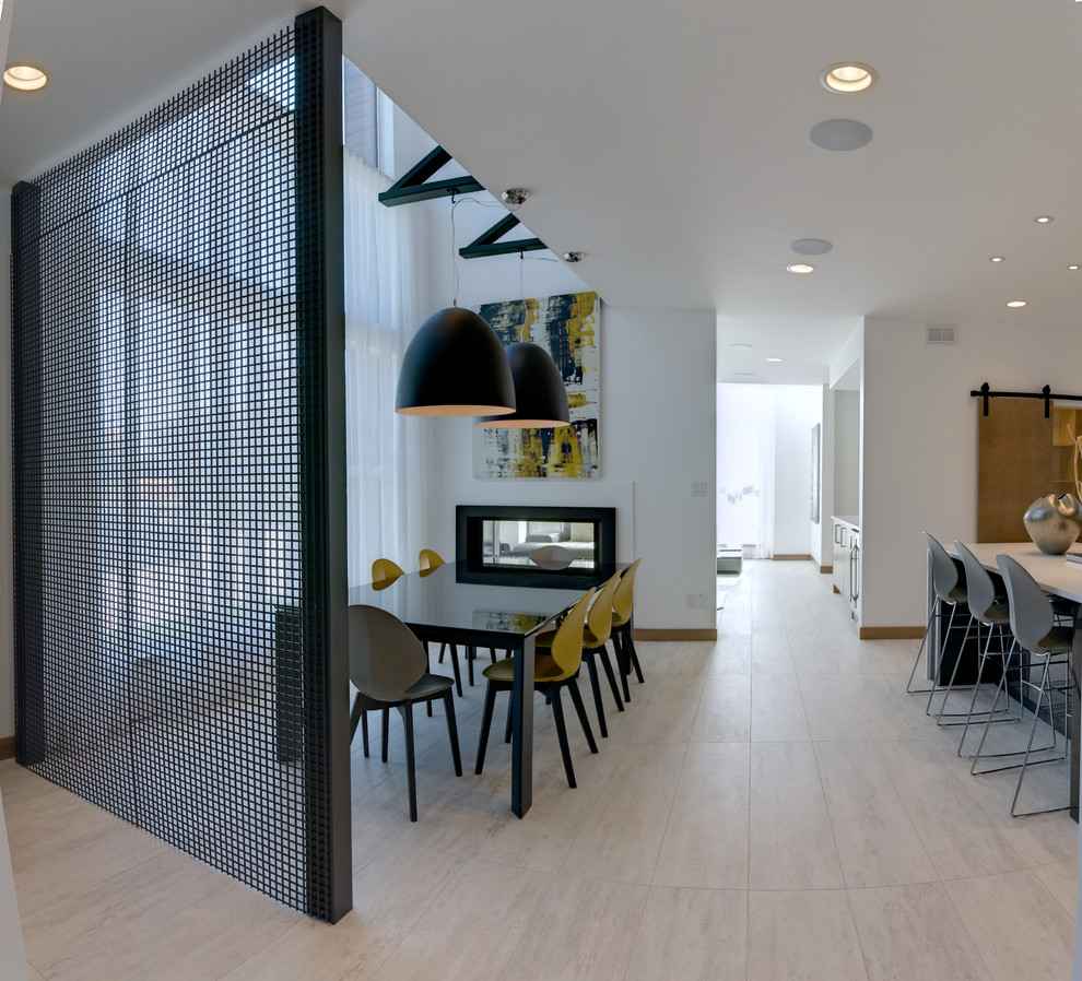 Foto di una sala da pranzo aperta verso la cucina moderna di medie dimensioni con pavimento con piastrelle in ceramica, camino bifacciale e cornice del camino in metallo