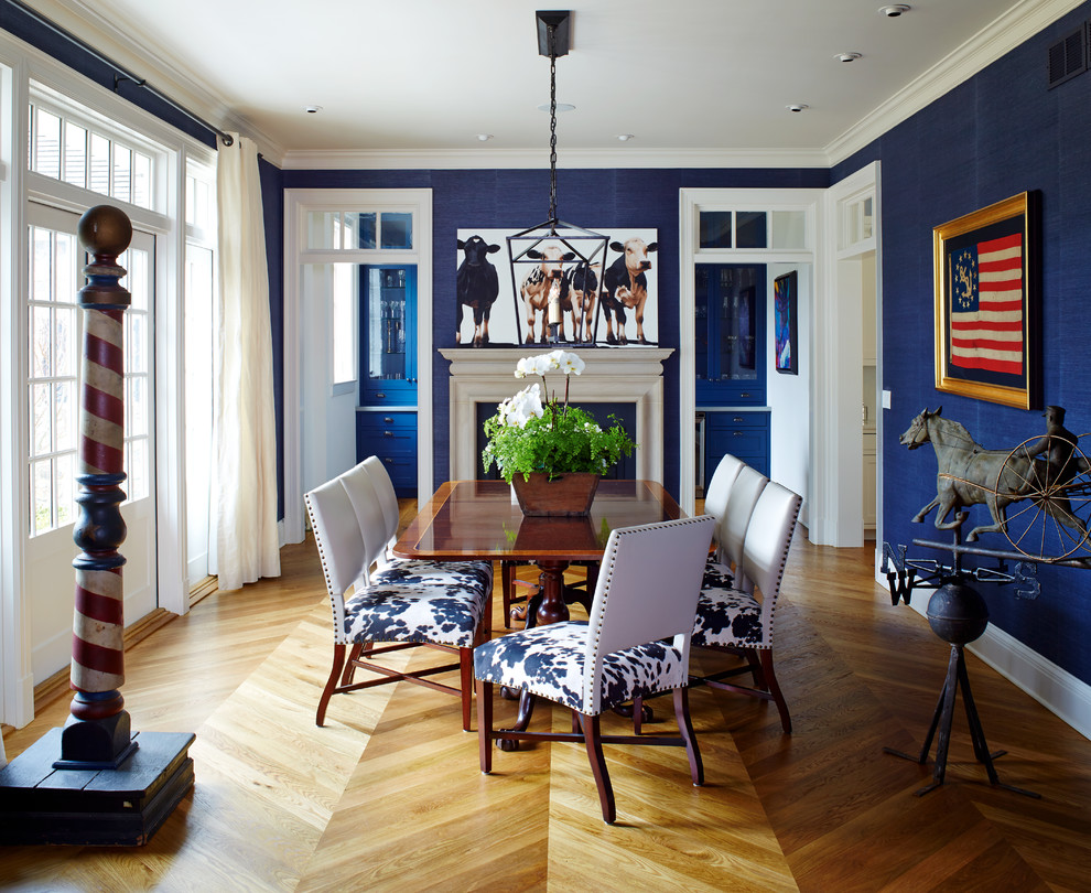 Imagen de comedor clásico de tamaño medio cerrado con paredes azules, suelo de madera en tonos medios, todas las chimeneas, marco de chimenea de madera, suelo marrón y cortinas