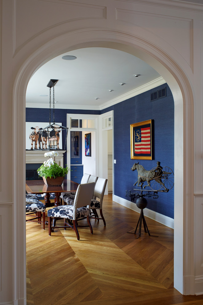 Ejemplo de comedor tradicional de tamaño medio cerrado con paredes azules, suelo de madera en tonos medios, todas las chimeneas, marco de chimenea de madera y suelo marrón