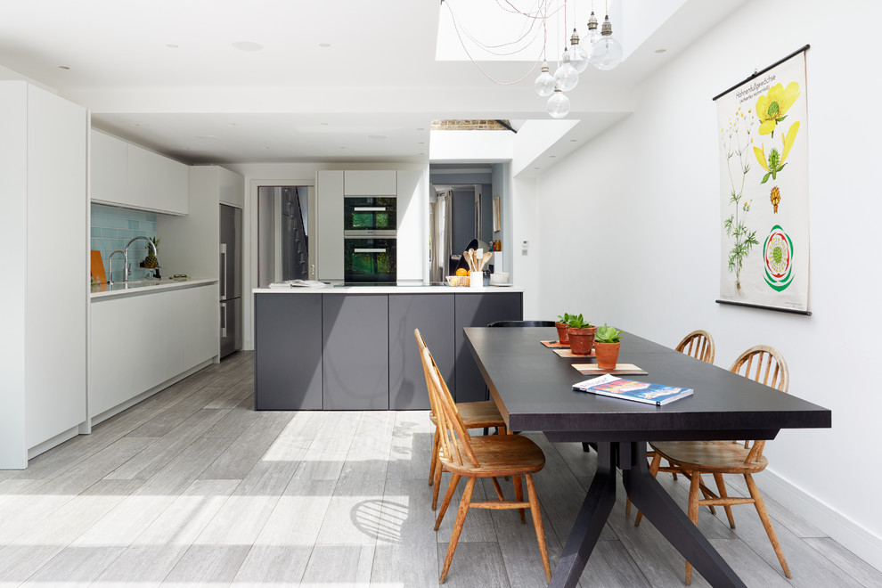 Идея дизайна: кухня-столовая в современном стиле с белыми стенами без камина