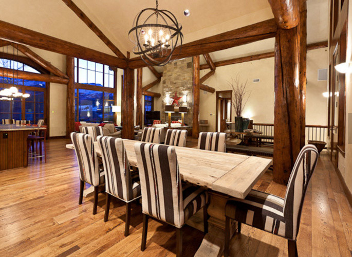 Пример оригинального дизайна: большая гостиная-столовая в стиле рустика с коричневыми стенами, паркетным полом среднего тона и коричневым полом без камина