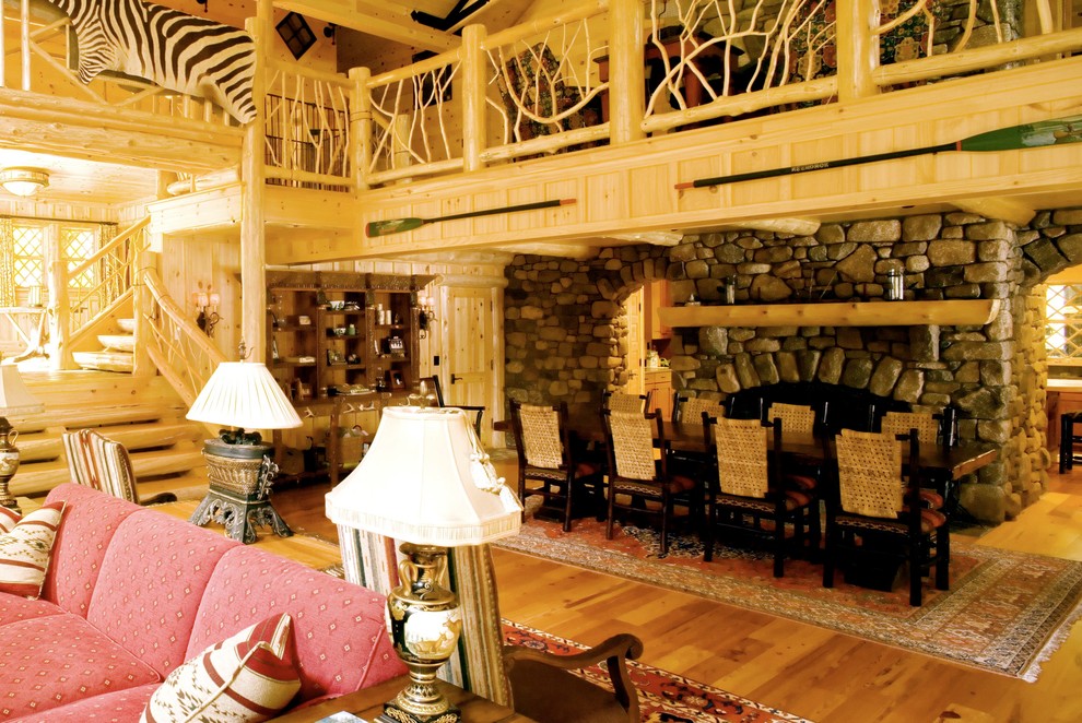 Inspiration pour une grande salle à manger ouverte sur le salon chalet avec un mur marron, un sol en bois brun, une cheminée double-face et un sol bleu.