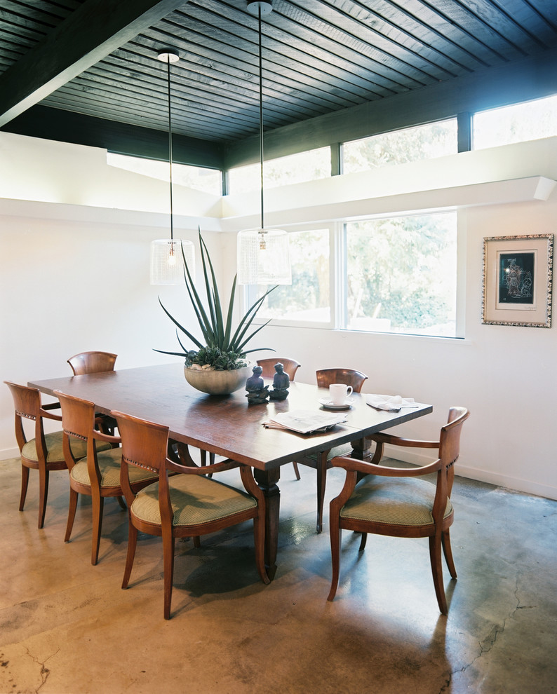 Immagine di una sala da pranzo moderna con pavimento in cemento