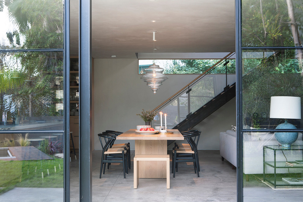 Стильный дизайн: гостиная-столовая среднего размера в современном стиле с бежевыми стенами и бетонным полом без камина - последний тренд