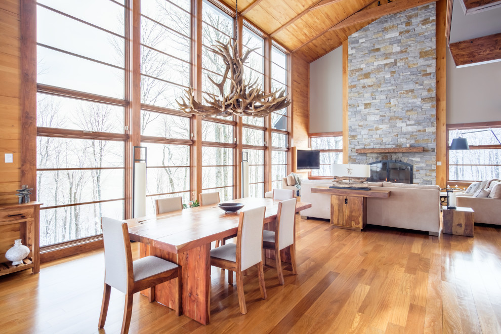 Immagine di una sala da pranzo aperta verso il soggiorno rustica con pavimento in legno massello medio, soffitto a volta, soffitto in legno e pareti in legno