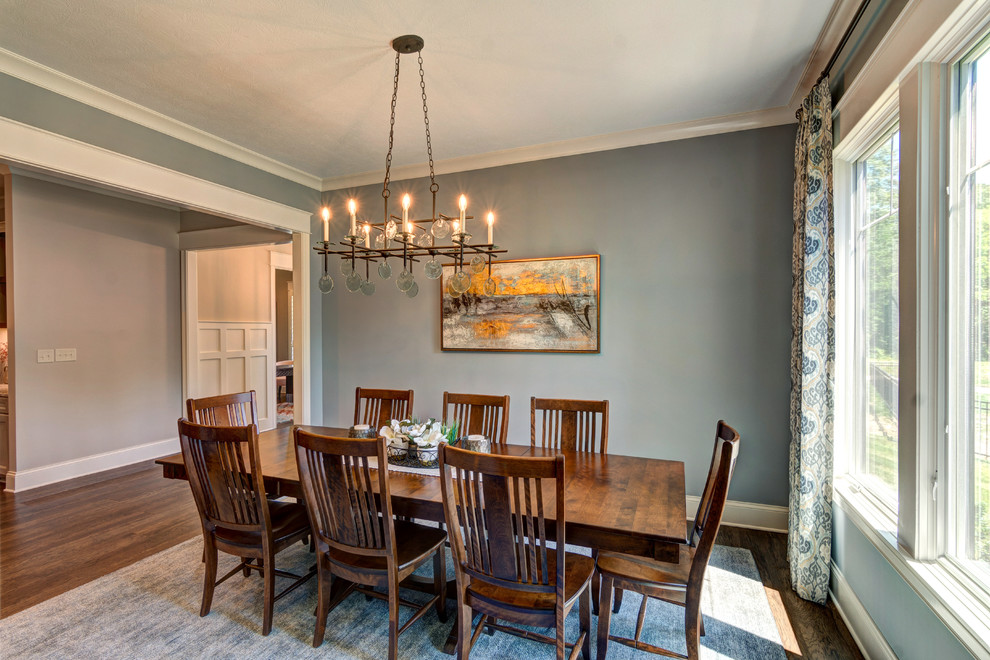 Immagine di una sala da pranzo aperta verso la cucina rustica di medie dimensioni con pareti blu, pavimento in vinile e pavimento marrone