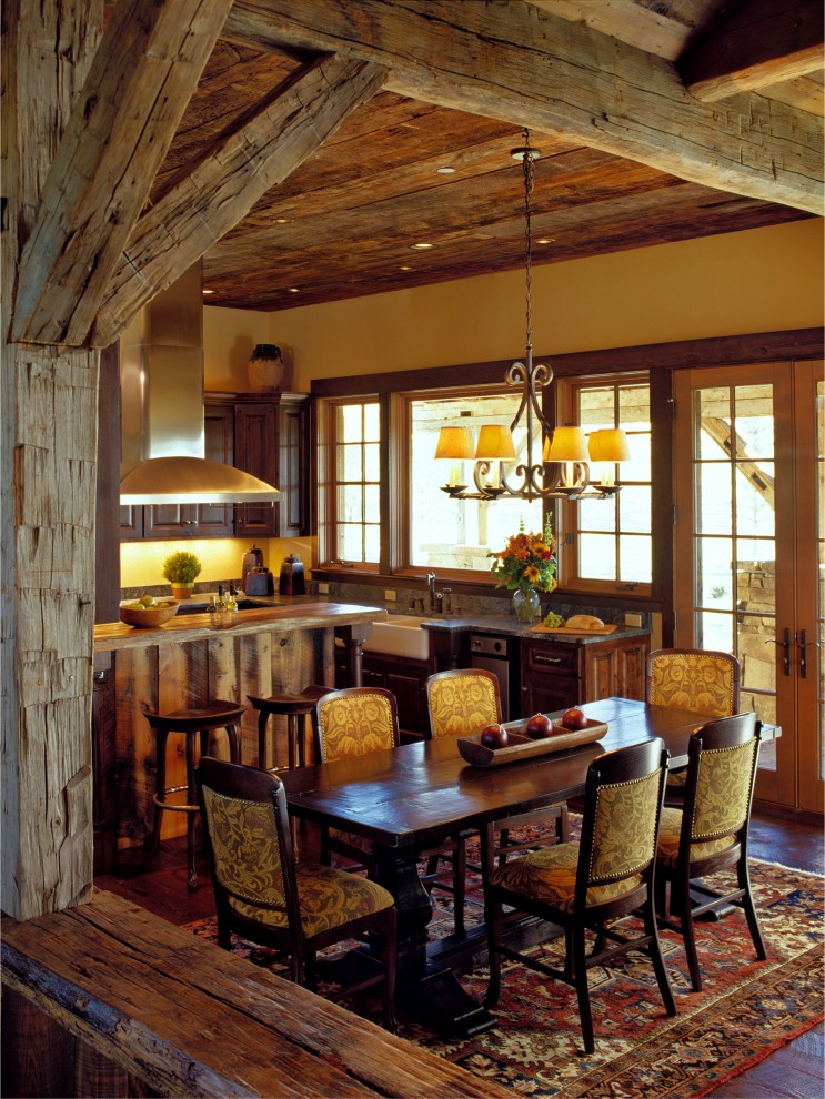 Esempio di una sala da pranzo aperta verso la cucina rustica con pareti gialle e parquet scuro
