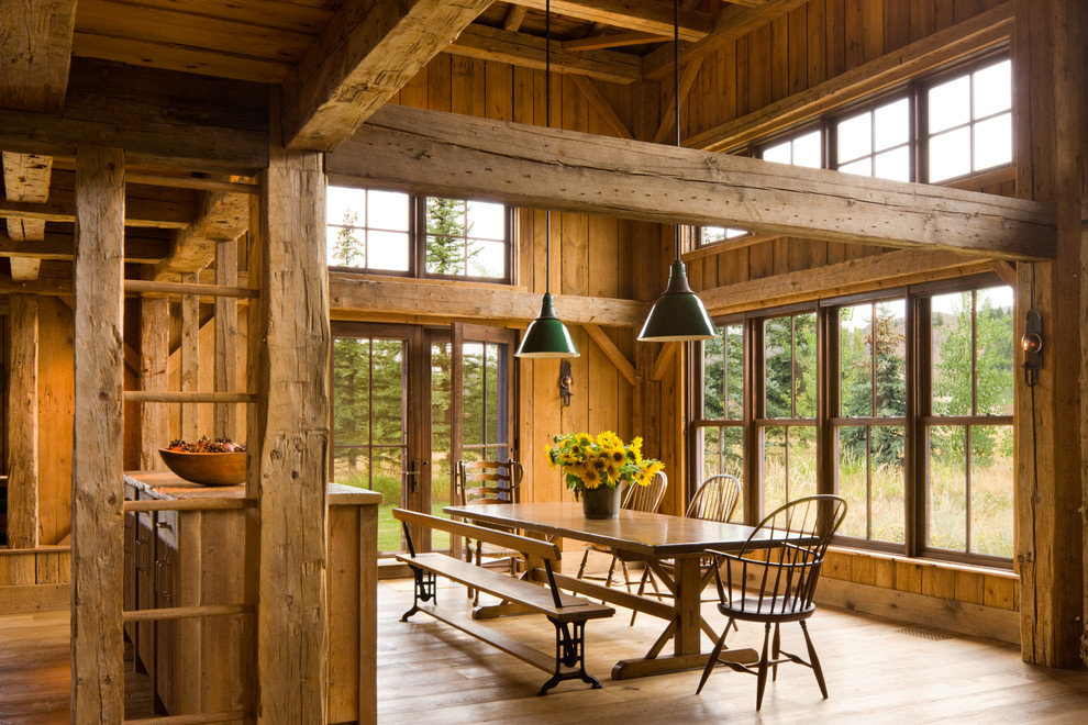 Idee per una sala da pranzo rustica con pavimento in legno massello medio e nessun camino