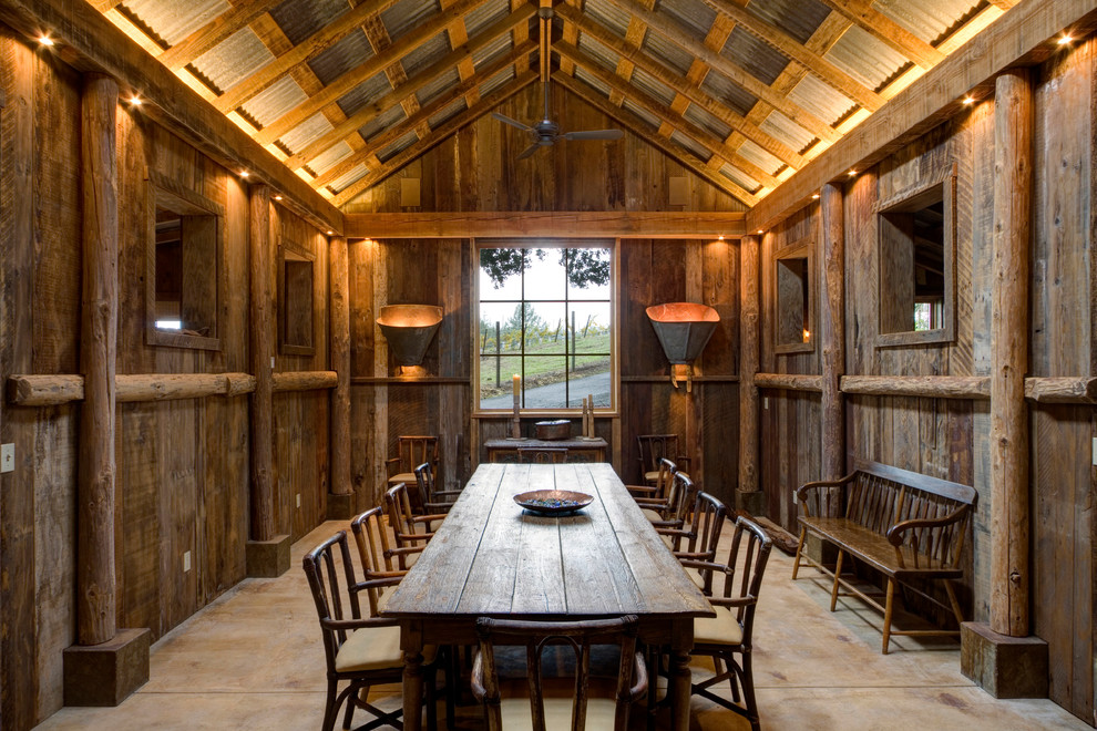 Foto di una sala da pranzo stile rurale chiusa con pareti marroni e pavimento in cemento