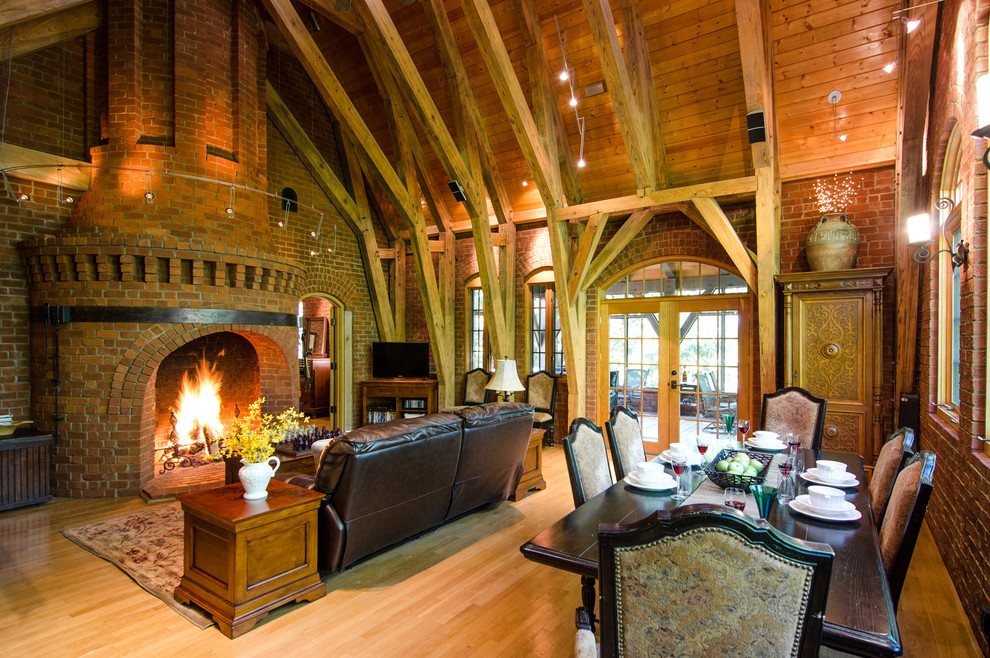 Immagine di una sala da pranzo aperta verso il soggiorno rustica con pavimento in legno massello medio