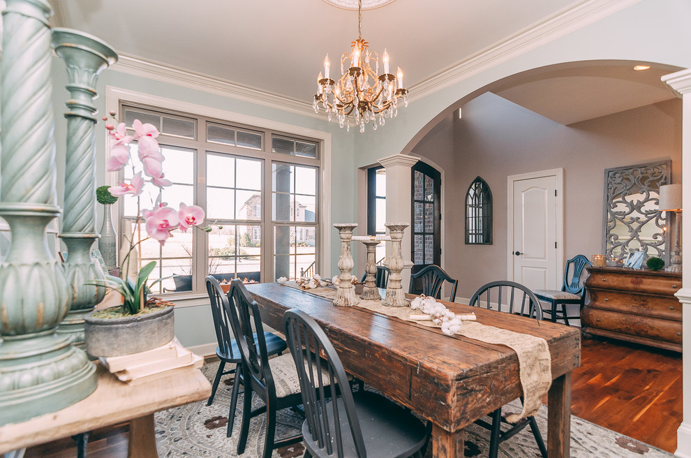Cette photo montre une salle à manger ouverte sur le salon romantique de taille moyenne avec un mur bleu et un sol en bois brun.