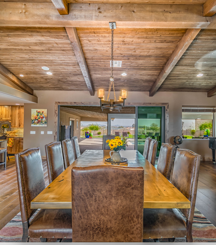 Esempio di una grande sala da pranzo aperta verso la cucina rustica con pareti beige e pavimento in legno massello medio
