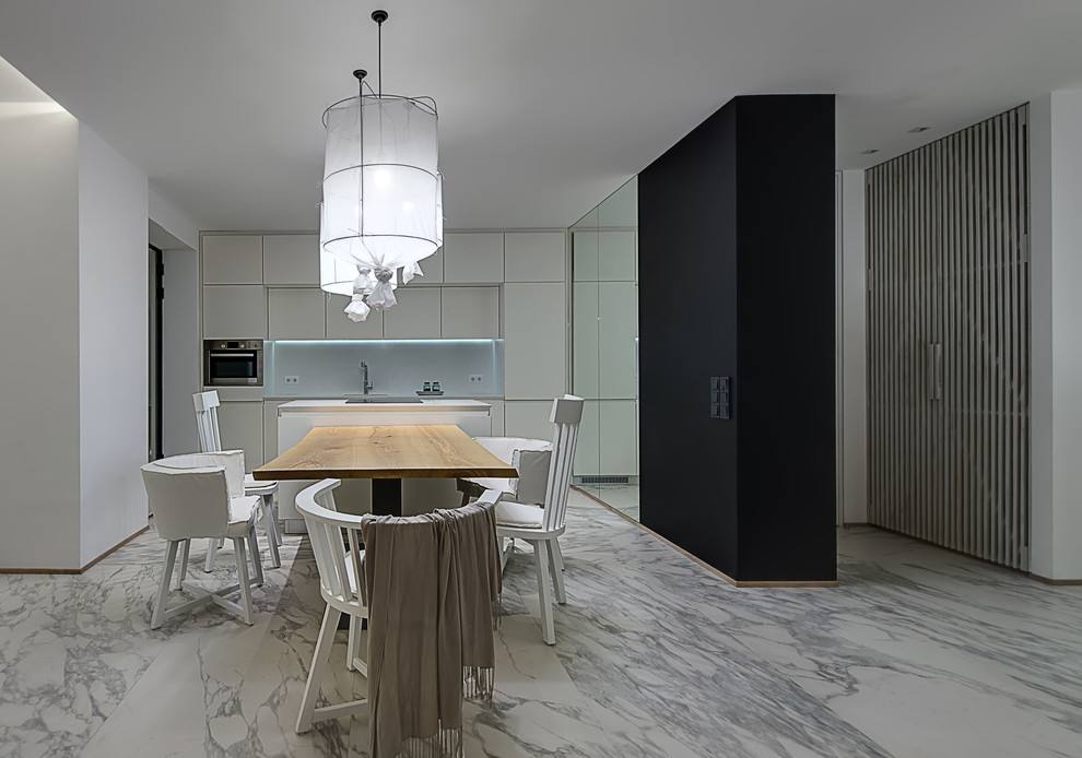 Foto di una sala da pranzo aperta verso la cucina di medie dimensioni con pareti bianche, pavimento in marmo e pavimento bianco