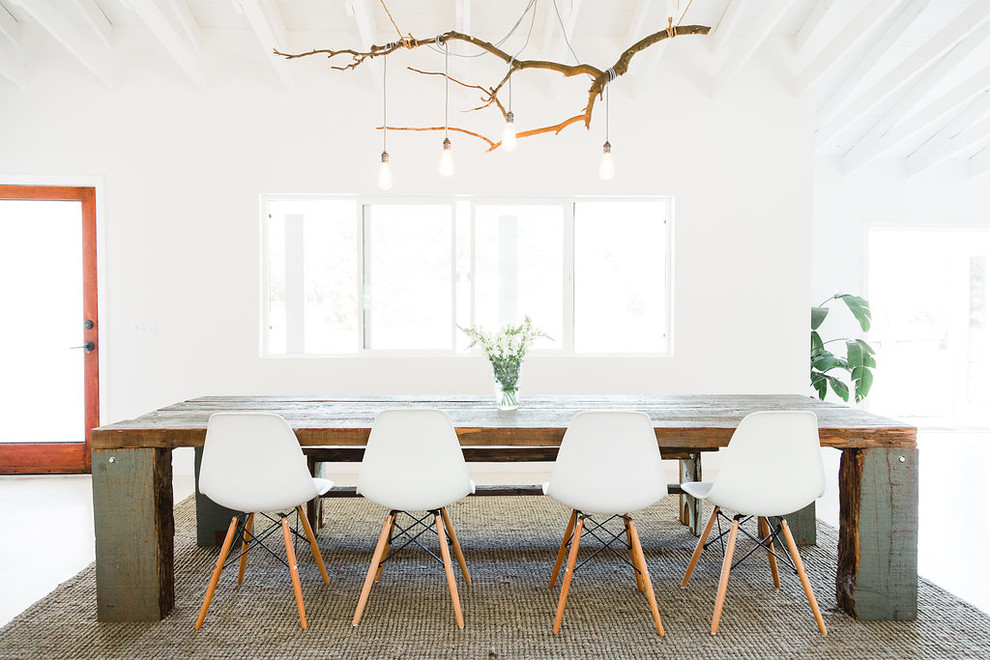 Immagine di una sala da pranzo aperta verso la cucina american style di medie dimensioni con pareti bianche e pavimento in cemento
