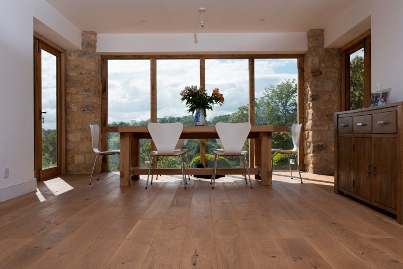 Modelo de comedor contemporáneo grande con suelo de madera clara