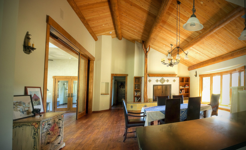Large rustic kitchen/dining room in San Diego with a standard fireplace, beige walls, medium hardwood flooring and brown floors.