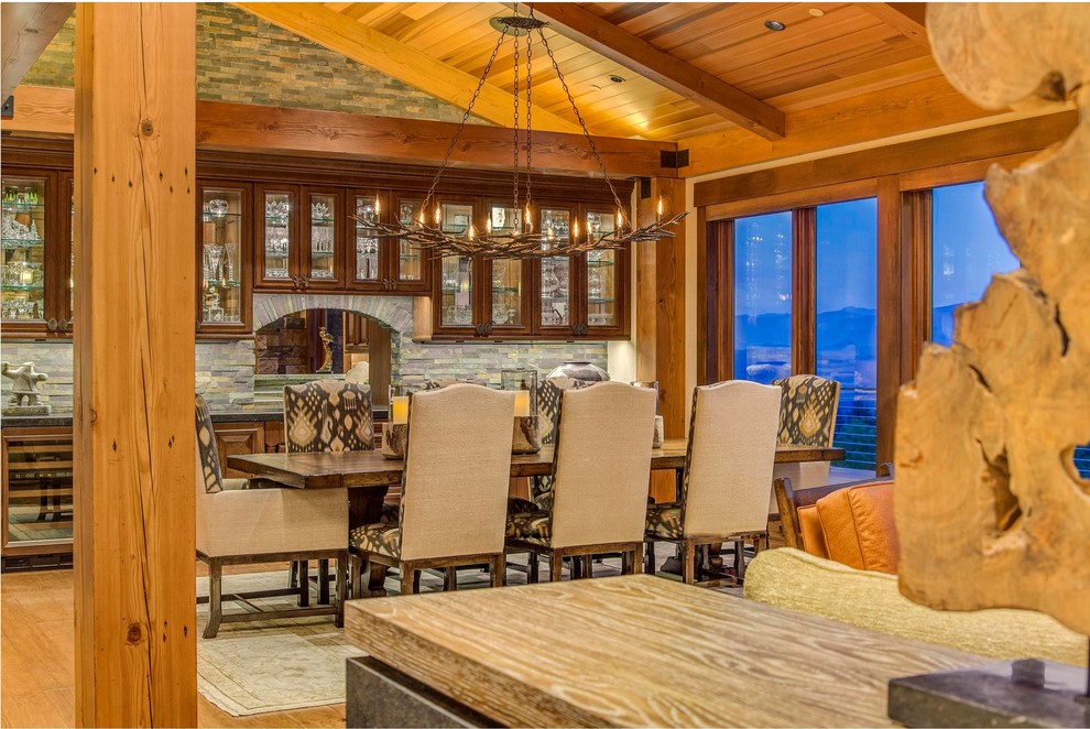 Exemple d'une grande salle à manger ouverte sur le salon montagne avec une cheminée standard et un manteau de cheminée en pierre.