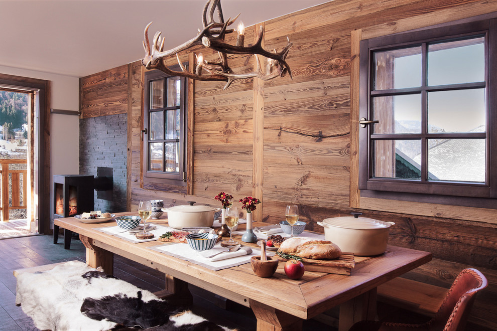 Esempio di una sala da pranzo aperta verso il soggiorno rustica di medie dimensioni con pareti marroni e pavimento in legno massello medio