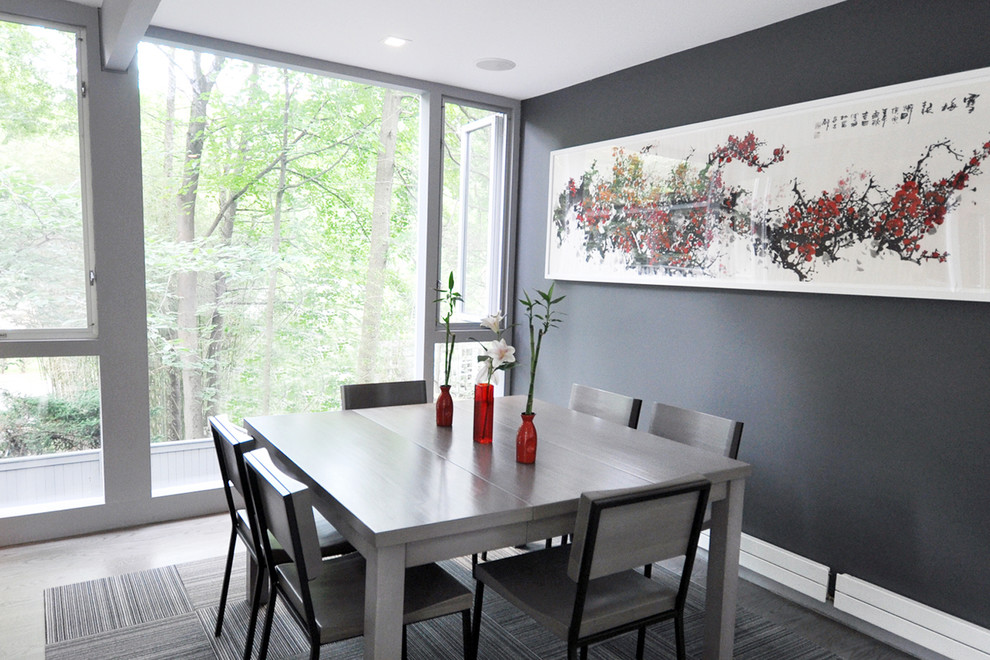 Example of a mid-sized minimalist medium tone wood floor great room design in New York with gray walls, a two-sided fireplace and a brick fireplace