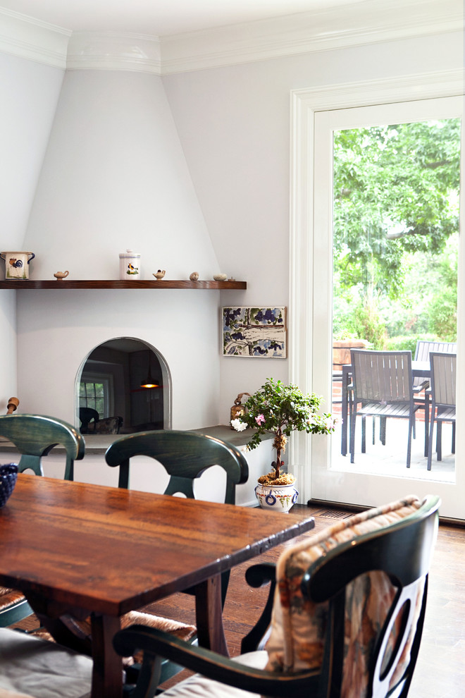 На фото: кухня-столовая среднего размера в стиле неоклассика (современная классика) с паркетным полом среднего тона, угловым камином, серыми стенами, фасадом камина из штукатурки и коричневым полом