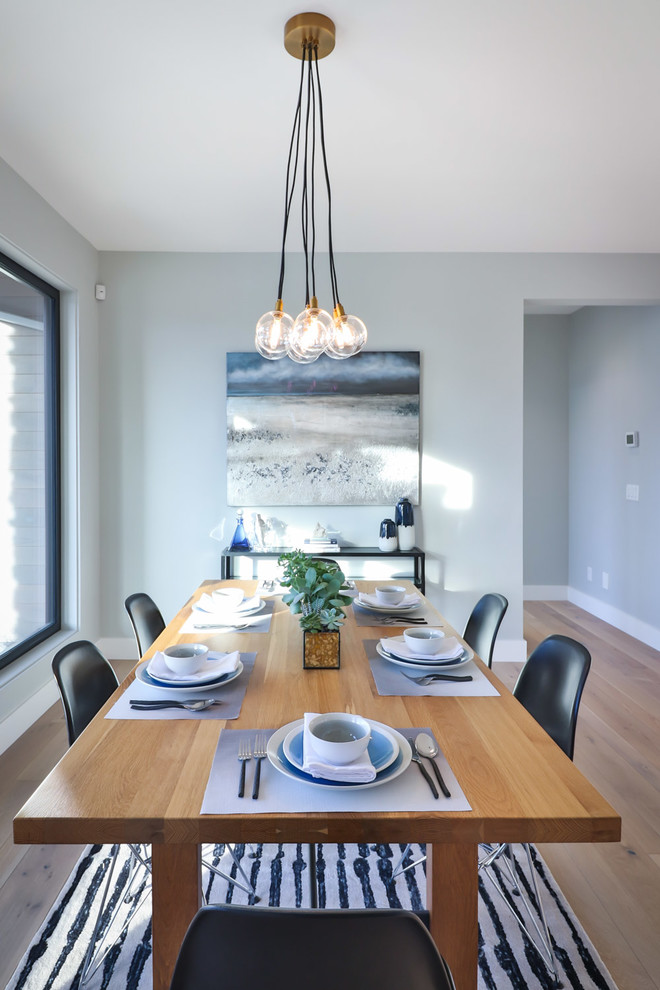 Idee per una sala da pranzo aperta verso la cucina design di medie dimensioni con pareti grigie, pavimento in legno massello medio e pavimento beige
