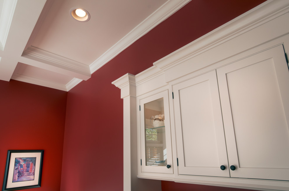 Cette image montre une salle à manger ouverte sur la cuisine traditionnelle de taille moyenne avec un mur rouge, parquet clair et aucune cheminée.