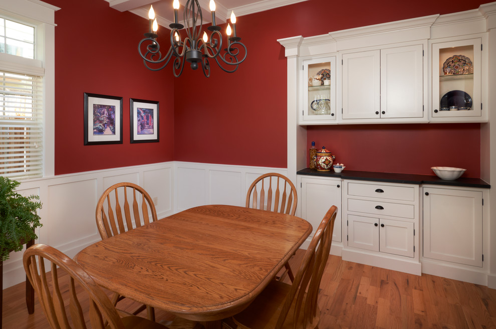 Aménagement d'une salle à manger ouverte sur la cuisine classique de taille moyenne avec un mur rouge, parquet clair et aucune cheminée.