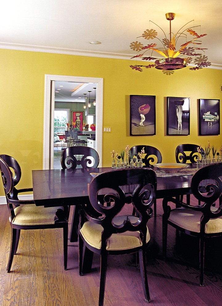 Foto de comedor actual grande cerrado sin chimenea con paredes amarillas, suelo de madera en tonos medios y suelo marrón