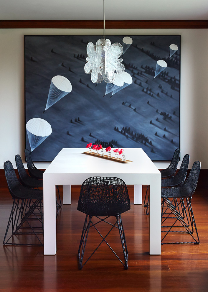 Foto di una sala da pranzo aperta verso la cucina minimalista di medie dimensioni con pareti bianche, parquet scuro e nessun camino