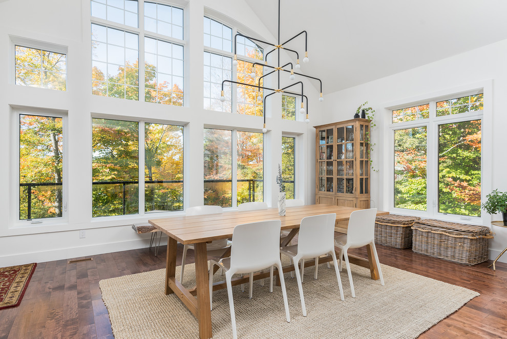 Photo of a contemporary dining room in Montreal with white walls, medium hardwood flooring and no fireplace.
