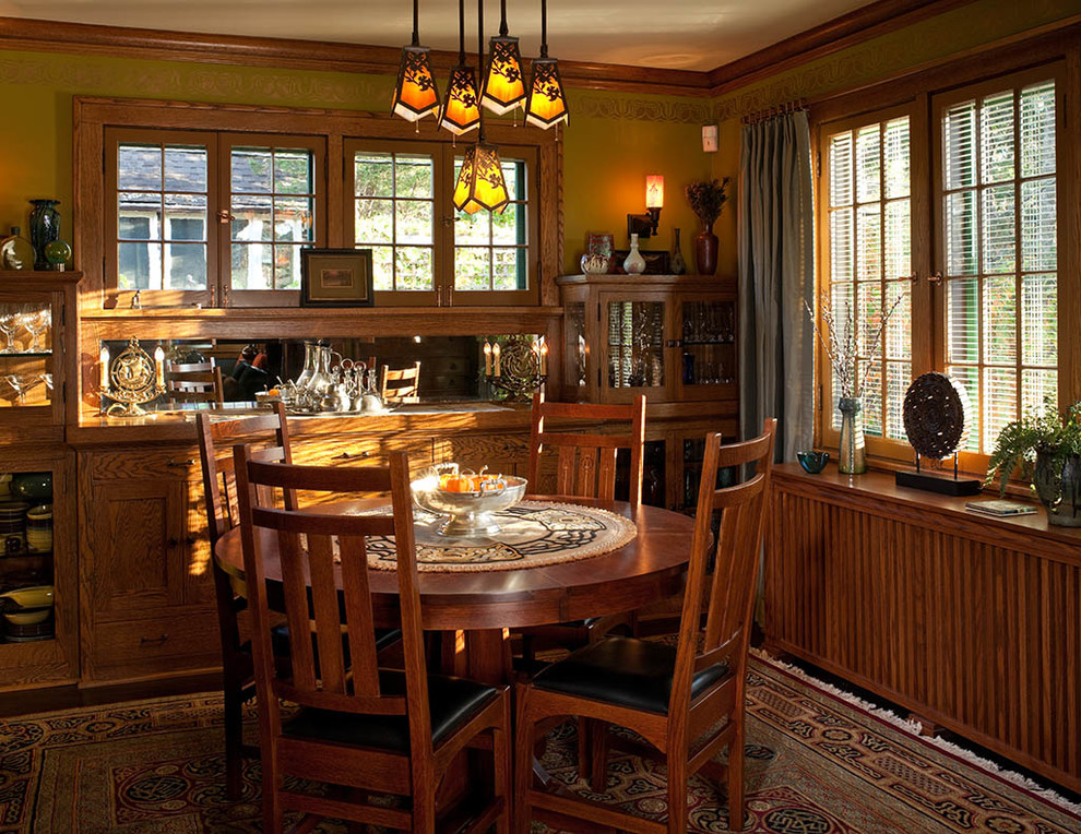 Exemple d'une salle à manger craftsman fermée avec parquet foncé, aucune cheminée et un mur marron.