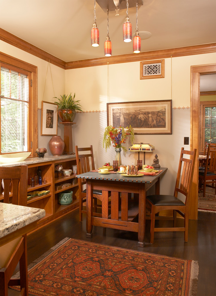 Inspiration pour une salle à manger ouverte sur la cuisine craftsman avec parquet foncé, un mur gris et aucune cheminée.