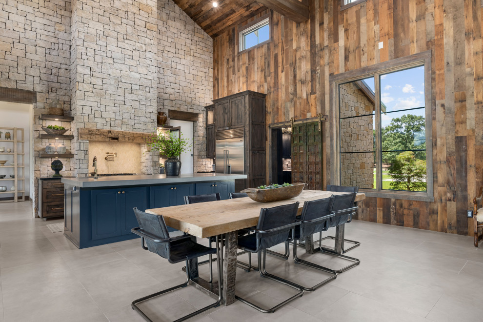 Esempio di una sala da pranzo aperta verso il soggiorno country con pareti marroni, pavimento grigio, soffitto a volta, soffitto in legno e pareti in legno