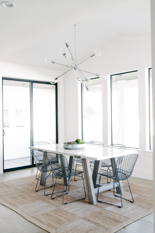Foto di una grande sala da pranzo aperta verso il soggiorno minimal con pareti bianche, parquet chiaro e pavimento beige
