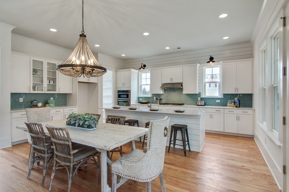 Example of a large beach style light wood floor and beige floor kitchen/dining room combo design in Charleston with white walls