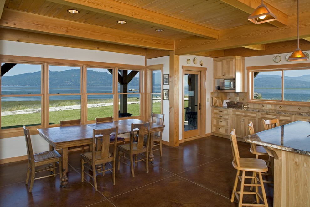 Cette photo montre une salle à manger ouverte sur le salon montagne de taille moyenne avec un mur blanc, sol en béton ciré, aucune cheminée et un sol marron.