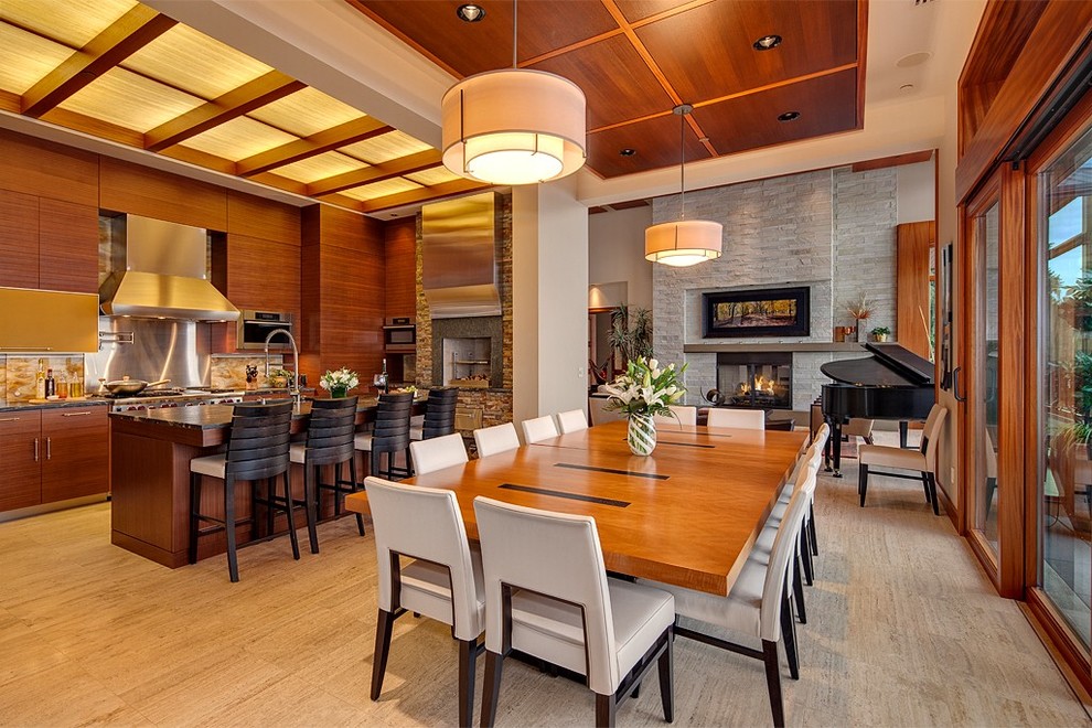 Cette image montre une salle à manger ouverte sur le salon design avec une cheminée standard et un manteau de cheminée en pierre.