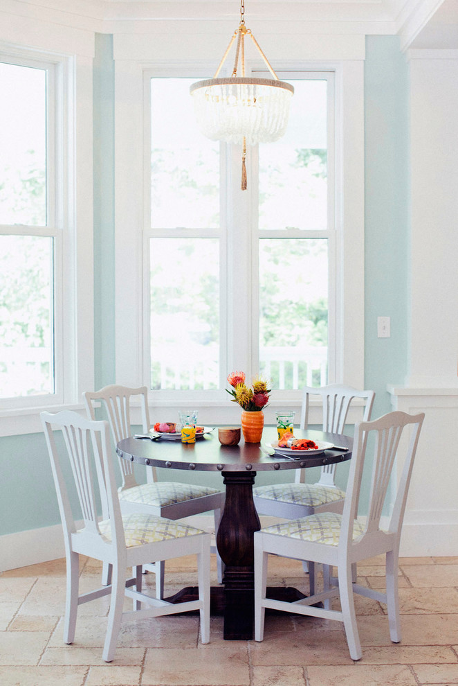 Immagine di una piccola sala da pranzo aperta verso la cucina chic con pareti blu, pavimento in pietra calcarea e nessun camino