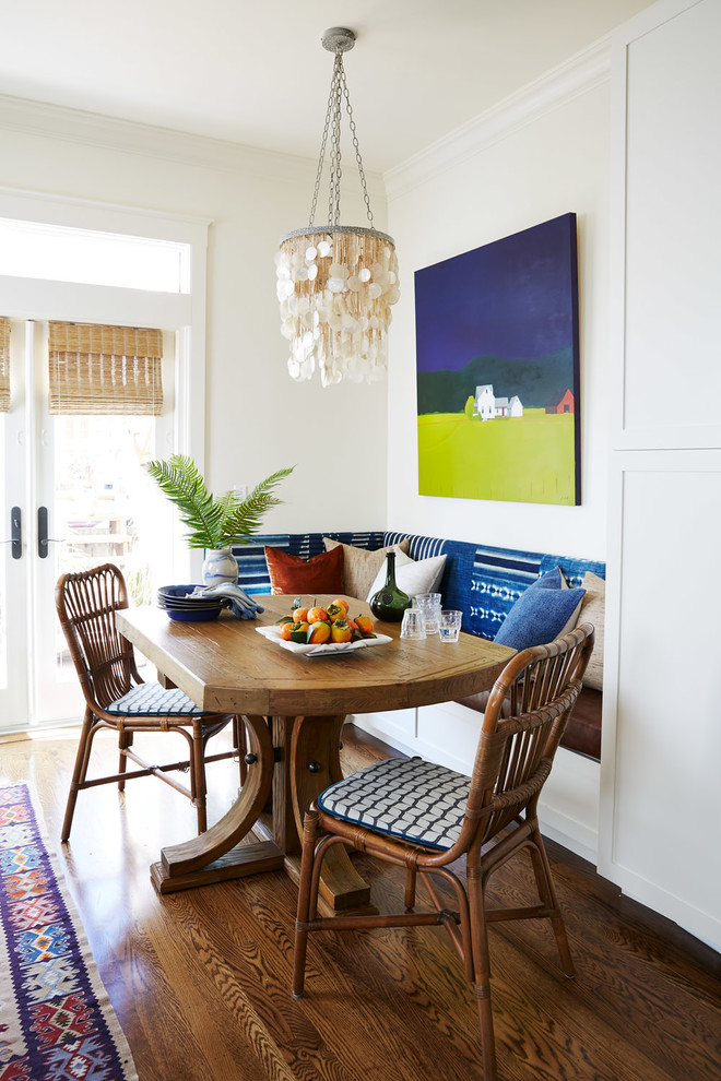 Cette photo montre une salle à manger ouverte sur la cuisine bord de mer de taille moyenne avec un mur blanc, un sol en bois brun, un sol marron et aucune cheminée.