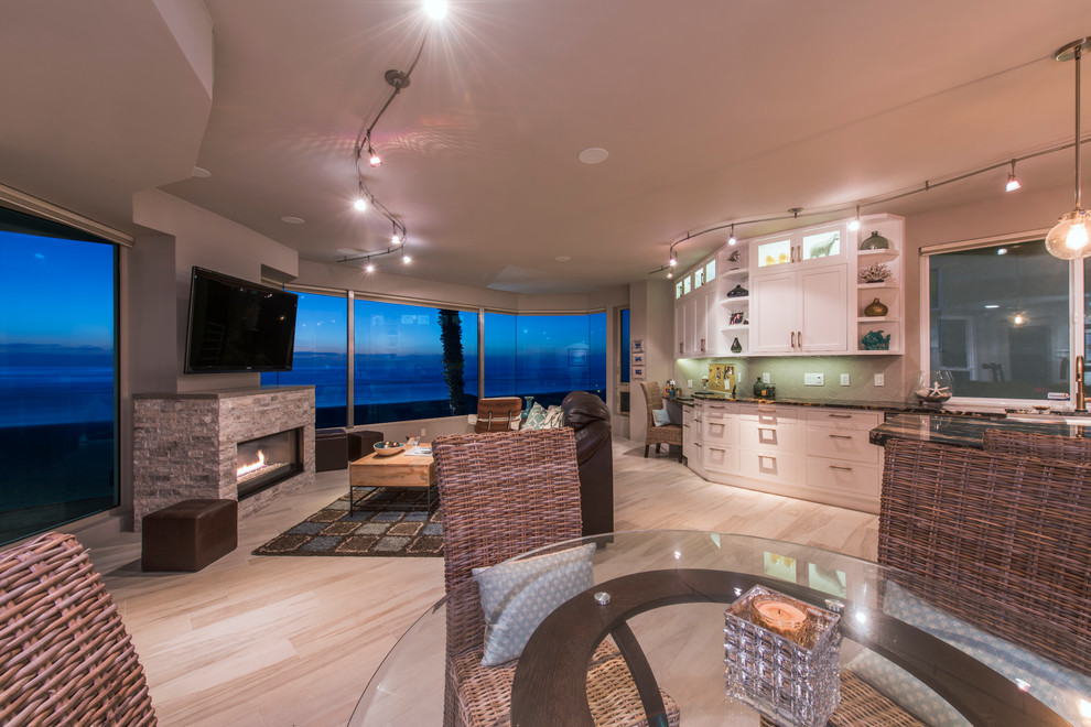 Large beach style light wood floor dining room photo in San Diego with beige walls, a standard fireplace and a stone fireplace