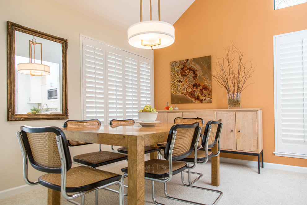 Стильный дизайн: кухня-столовая среднего размера в современном стиле с оранжевыми стенами, ковровым покрытием, стандартным камином и фасадом камина из камня - последний тренд